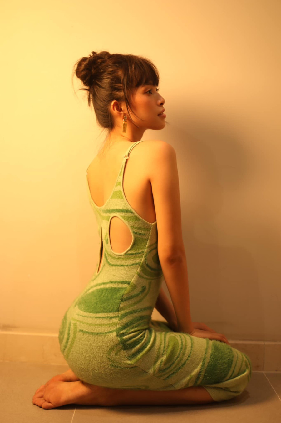 Mẫu váy hai dây gợi cảm với những khoảng cut out sau lưng, được Tiểu Vy phối cùng bông tai Chanel và tóc buộc gọn cao.