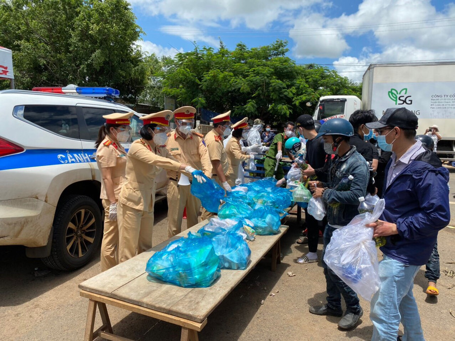 Công an giao thông tỉnh hỗ trợ lương thực cho công dân từ vùng dịch trở về qua địa bàn tỉnh. Ảnh: Lê Anh
