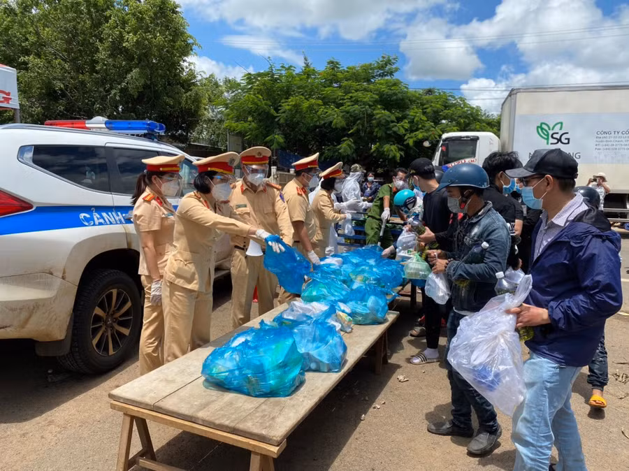 Công an giao thông tỉnh hỗ trợ lương thực cho công dân từ vùng dịch trở về qua địa bàn tỉnh. Ảnh: Lê Anh