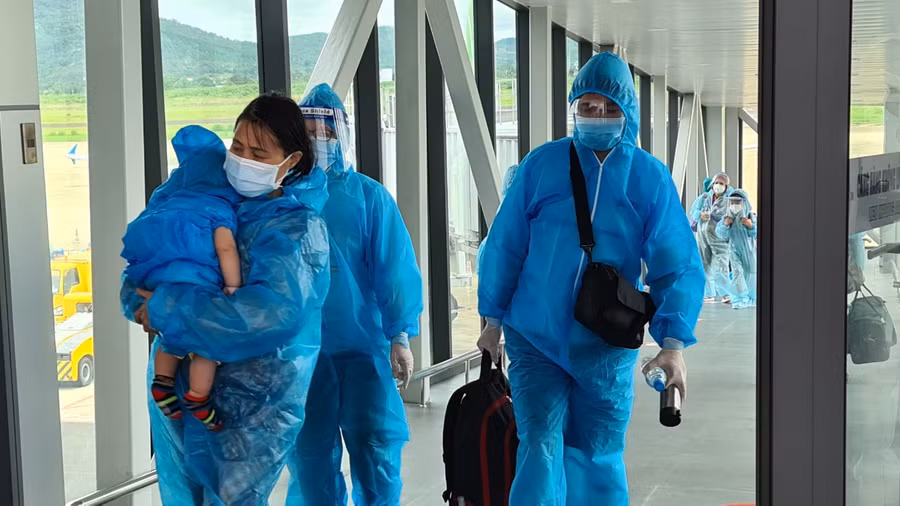 Một thai phụ có con nhỏ về đến sân bay Liên Khương. Ảnh: Lâm Viên