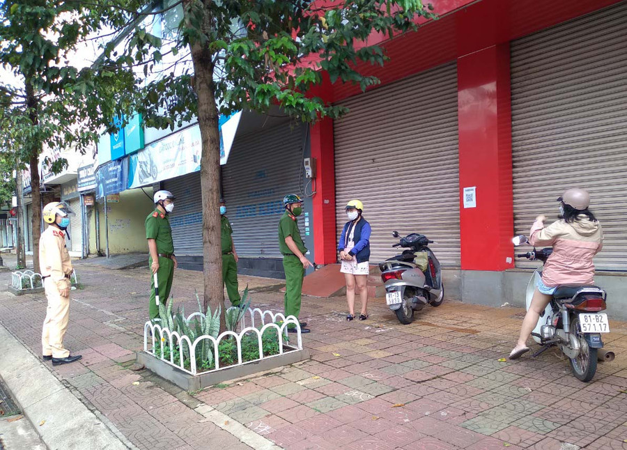 Lực lượng chức năng tổ tuần tra số 7, Công an TP. Pleiku nhắc nhở 2 công dân ra đường trong trường hợp không cần thiết trên đường Hùng Vương. Ảnh: Lê Anh