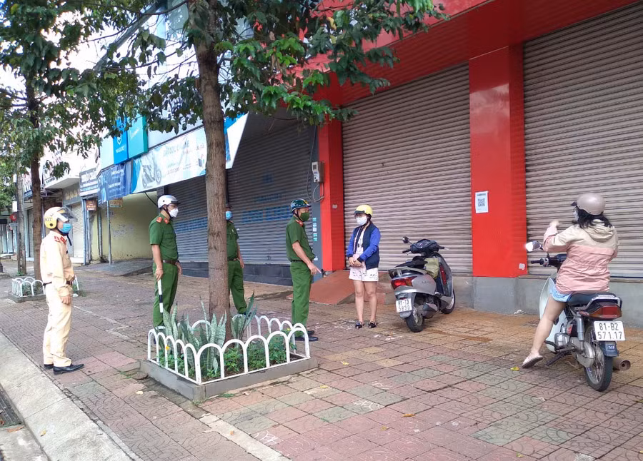 Lực lượng chức năng tổ tuần tra số 7, Công an TP. Pleiku nhắc nhở 2 công dân ra đường trong trường hợp không cần thiết trên đường Hùng Vương. Ảnh: Lê Anh