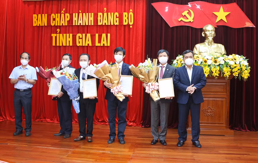 Bí thư Tỉnh ủy Hồ Văn Niên và Chủ tịch UBND tỉnh Võ Ngọc Thành trao quyết định và tăng hoa các đồng chí được điều động nhận nhiệm vụ mới. Ảnh: Quang Tấn