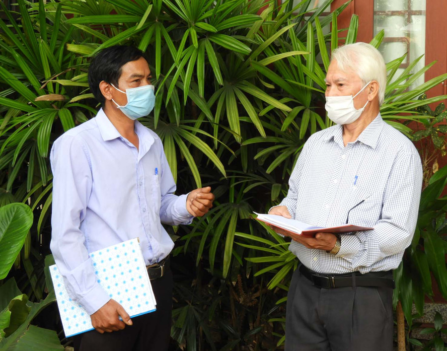 Ông Nguyễn Quang Lớn (bìa phải) trao đổi với Chủ tịch Ủy ban MTTQ Việt Nam xã Ia Yok về công tác ủng hộ phòng-chống dịch Covid-19. Ảnh: Thanh Nhật