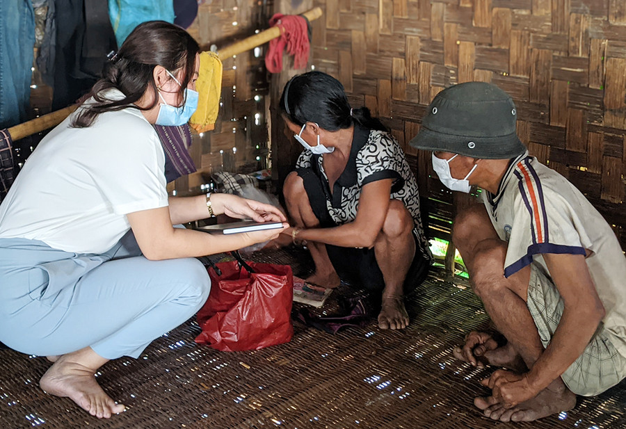 Cô giáo Trần Duy Soan My (bìa trái) đang hỗ trợ phụ huynh có con trong độ tuổi làm hồ sơ nhập học. Ảnh: Nguyễn Hiền