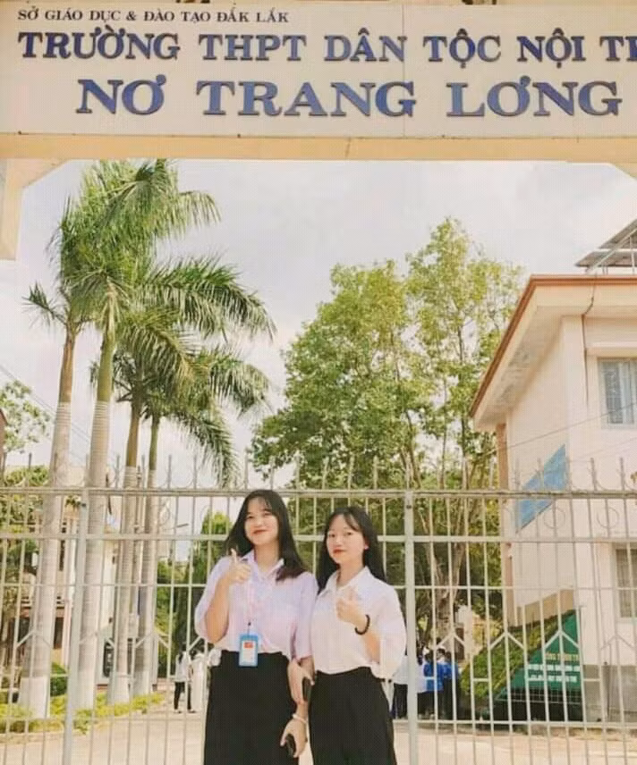 Hoàng Thị Ngọc (trái) chụp hình cùng bạn trước cổng trường. Ảnh: NVCC