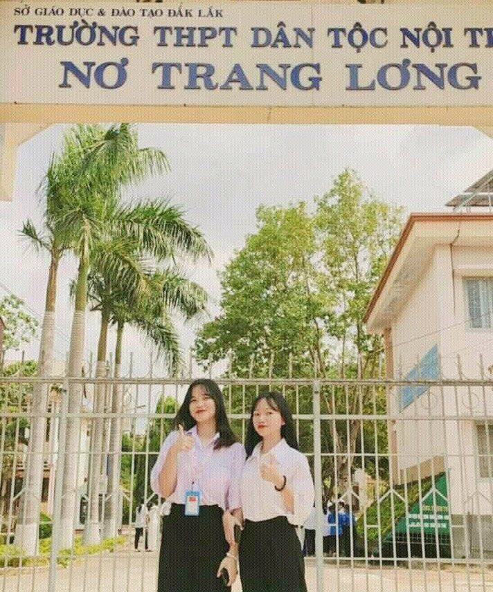 Hoàng Thị Ngọc (trái) chụp hình cùng bạn trước cổng trường. Ảnh: NVCC