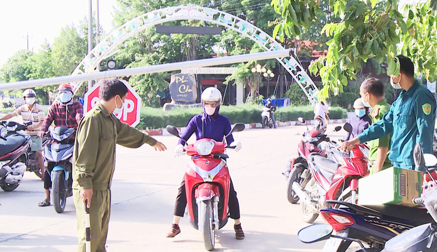  Lực lượng chức năng tại chốt kiểm soát liên ngành phòng-chống dịch bệnh Covid-19 giáp ranh giữa xã Phú Cần với thị trấn Phú Túc kiểm soát người ra vào vùng phong tỏa. Ảnh: Lê Nam