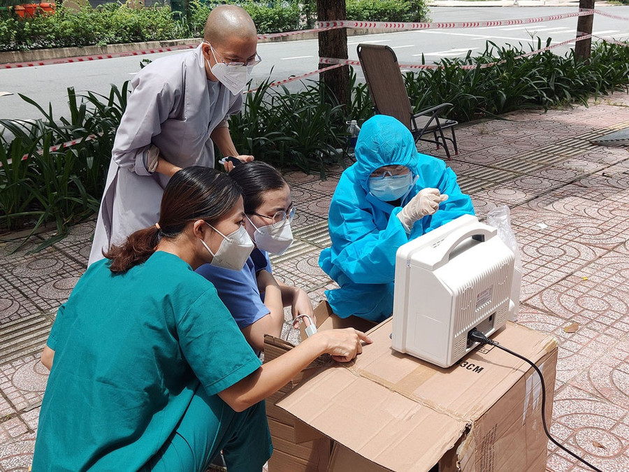 BS Trần Ngọc Hoàng Dung (bìa trái) và điều dưỡng Ngọc tìm hiểu sử dụng máy do nhóm tình nguyện viên Phật giáo trao tặng. Ảnh: Như Lịch