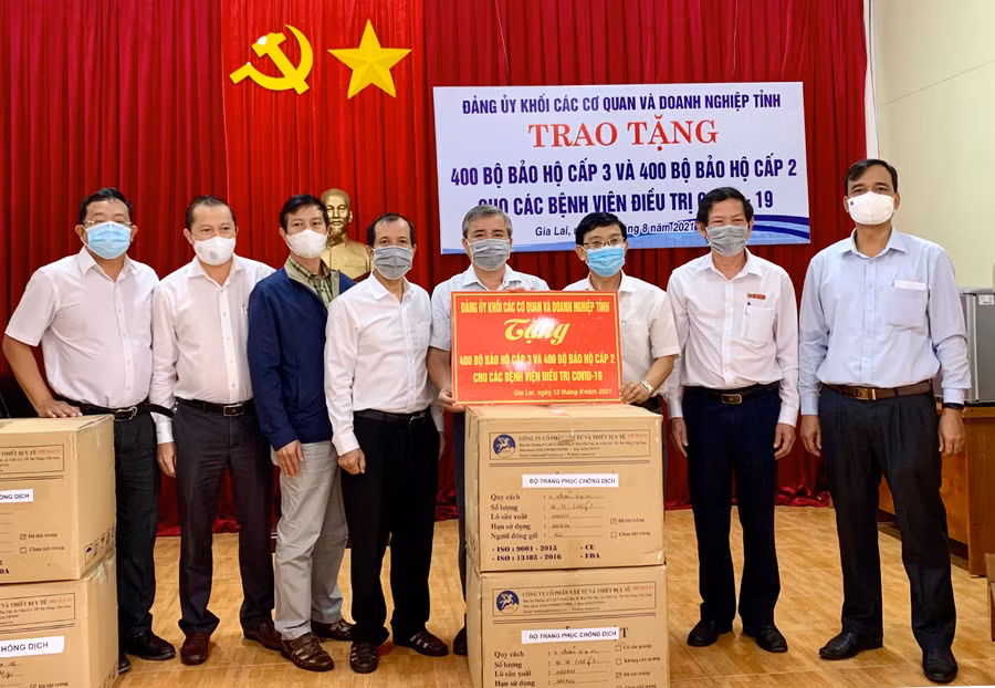  Đại diện Đảng ủy Khối các Cơ quan và Doanh nghiệp tỉnh cùng các nhà tài trợ trao tặng trang phục bảo hộ cho ngành Y tế Gia Lai. Ảnh: Như Nguyện