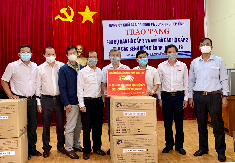 Đại diện Đảng ủy Khối các Cơ quan và Doanh nghiệp tỉnh cùng các nhà tài trợ trao tặng trang phục bảo hộ cho ngành Y tế Gia Lai. Ảnh: Như Nguyện  Đại diện Đảng ủy Khối các Cơ quan và Doanh nghiệp tỉnh cùng các nhà tài trợ trao tặng trang phục bảo hộ cho ngành Y tế Gia Lai. Ảnh: Như Nguyện