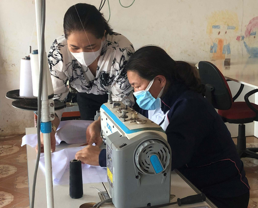  Chị Nguyễn Thị Thanh Trâm (ngồi) trao đổi về các chi tiết trong sản phẩm gia công với Chủ nhiệm Tổ hợp tác. Ảnh: Anh Huy