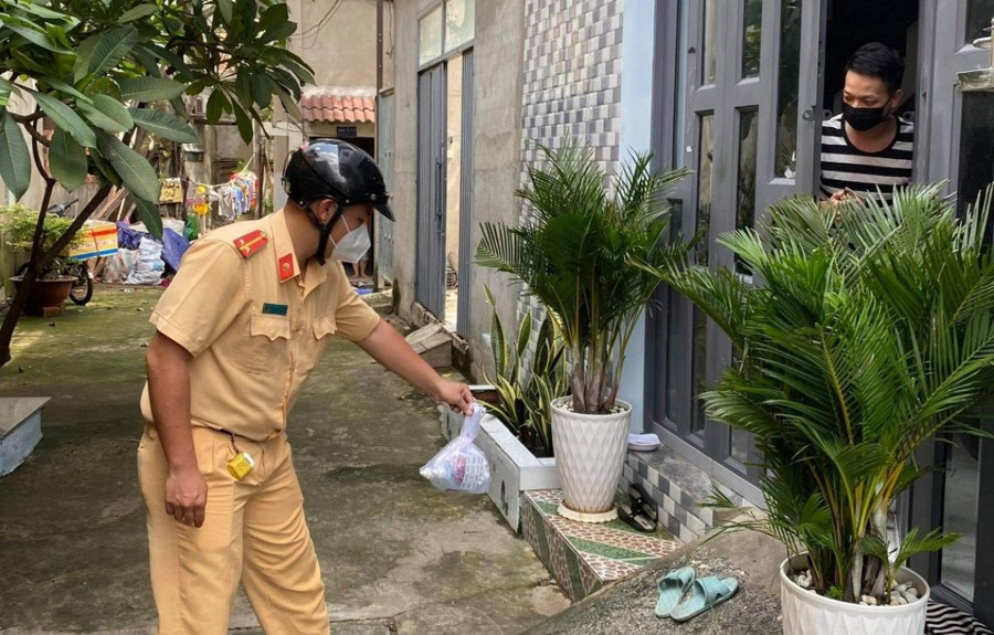 Anh Tuấn Anh phát túi thuốc cho gia đình có thành viên là F0. Ảnh: Tấn Đạt