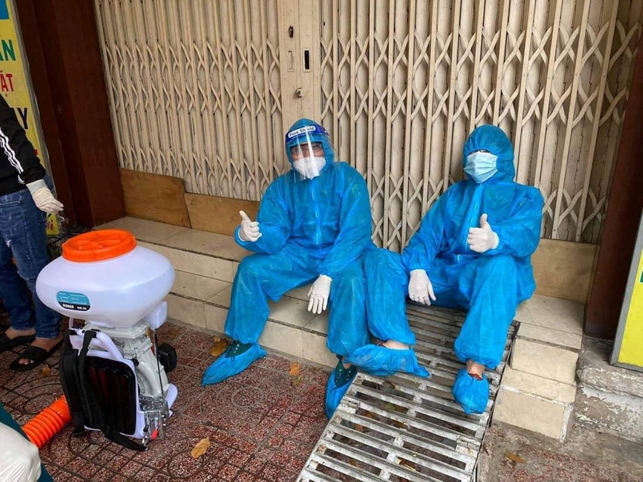 Bình (phải) cùng đồng đội kiệt sức sau khi hỗ trợ công tác xịt khử khuẩn. Ảnh: NVCC