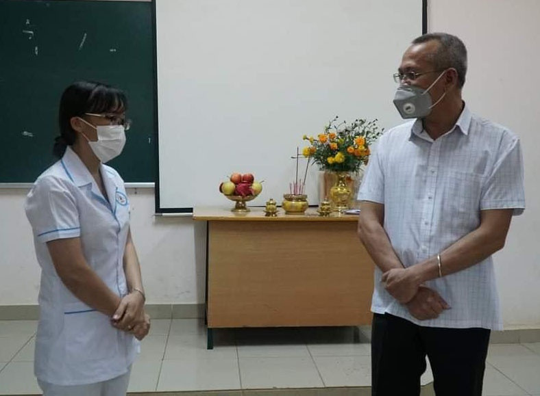Ông Nay Phi La, Giám đốc Sở Y tế Đắk Lắk, chia buồn, động viên nữ điều dưỡng trong khu cách ly. Ảnh: NVCC