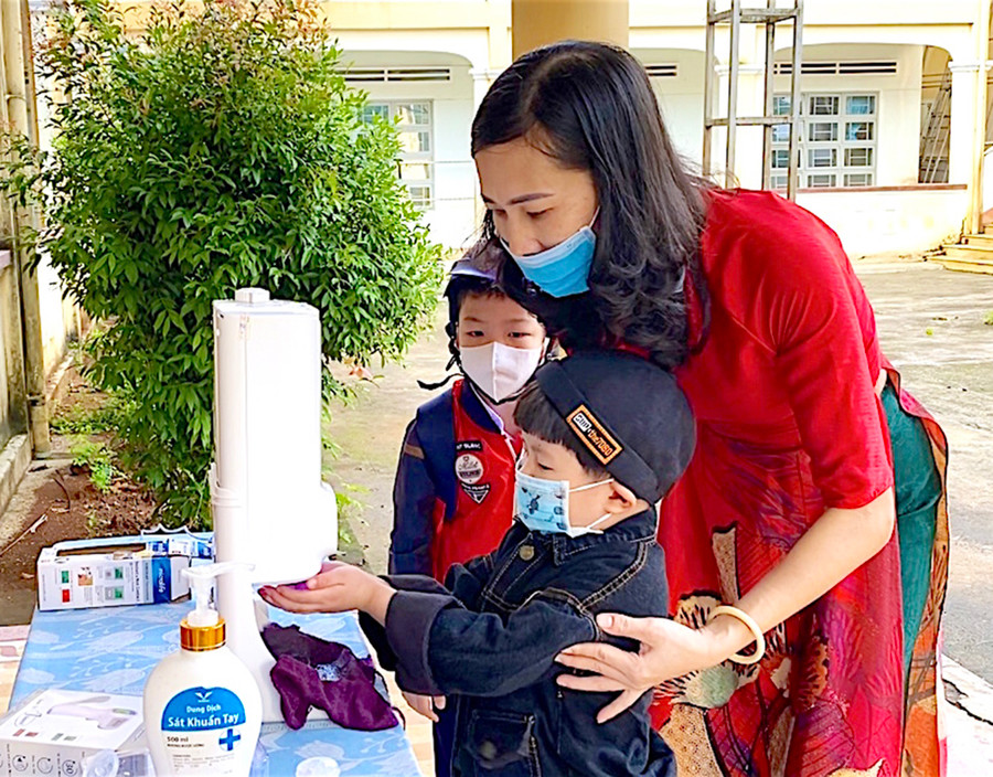 Giáo viên Trường Tiểu học Võ Thị Sáu (phường Hội Thương, TP. Pleiku) hướng dẫn học sinh rửa tay sát khuẩn tay trước khi vào lớp học. Ảnh: Ngọc Thu