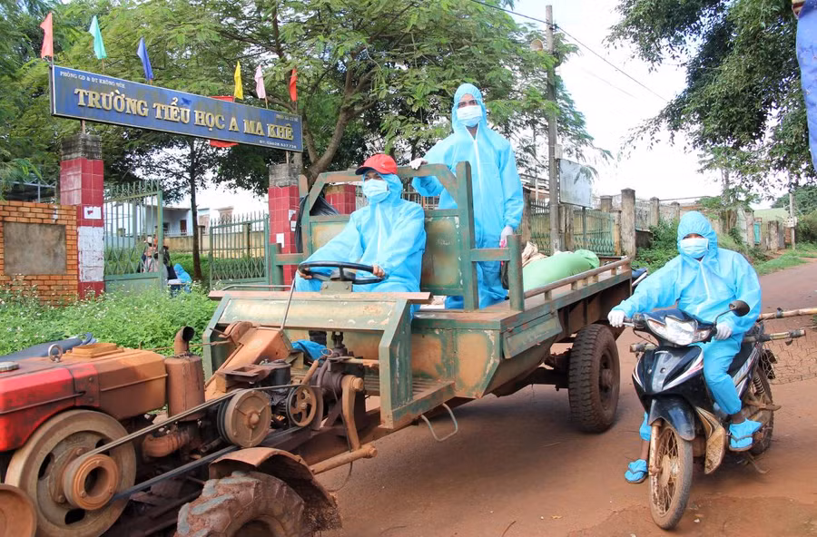 Thanh niên tình nguyện xã Cư Né (huyện Krông Búk) dùng xe cày vận chuyển nhu yếu phẩm hỗ trợ các hộ dân trong khu vực phong tỏa ở buôn Drao.