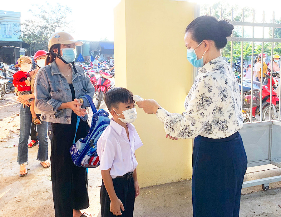 Học sinh Trường Tiểu học Nay Der (xã Ia Rsươm, huyện Krông Pa) được đo thân nhiệt và sát khuẩn tay từ cổng trường. Ảnh: Vũ Chi Học sinh Trường Tiểu học Nay Der (xã Ia Rsươm, huyện Krông Pa) được đo thân nhiệt và sát khuẩn tay từ cổng trường. Ảnh: Vũ Chi