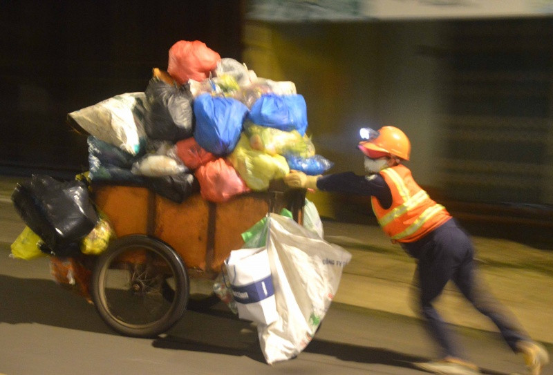 Nữ công nhân thu gom rác ban đêm trên đường Đồng Tiến, TP.Pleiku. Nữ công nhân thu gom rác ban đêm trên đường Đồng Tiến, TP.Pleiku.