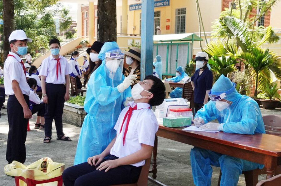  Nhân viên y tế lấy mẫu xét nghiệm cho học sinh tại Trường THCS Phạm Hồng Thái, TP. Pleiku. Ảnh: Hùng Linh
