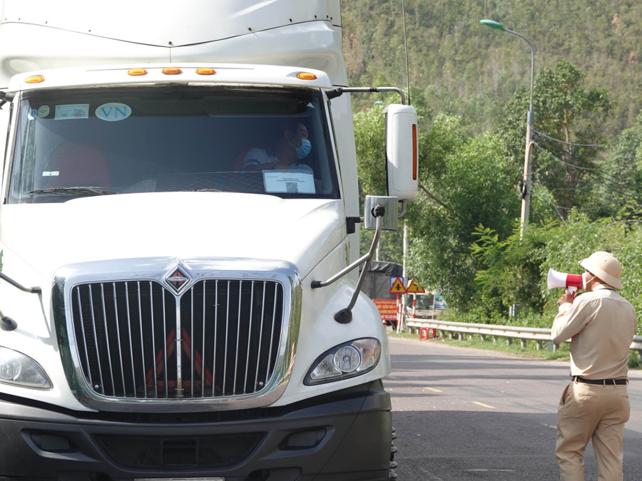 Kiểm tra giấy đi đường của tài xế tại chốt kiểm soát y tế quốc lộ 1D. Ảnh: HOÀNG TRỌNG