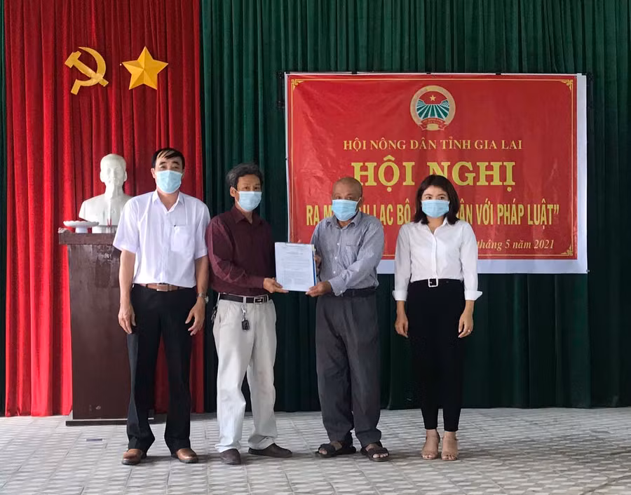 Đại diện lãnh đạo UBND xã Ia Hiao trao quyết định thành lập Ban Chủ nhiệm cho thành viên Câu lạc bộ Nông dân với pháp luật. Ảnh: Vũ Chi