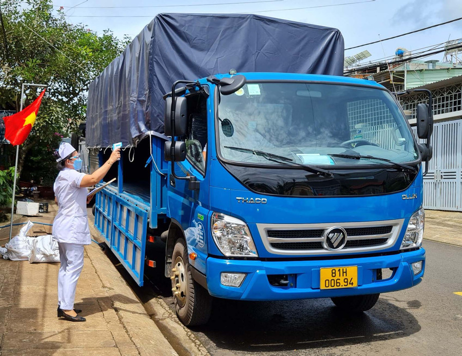 Cán bộ y tế phường Ia Kring (TP. Pleiku) kiểm tra y tế một trường hợp tài xế xe luồng xanh vừa di chuyển về địa bàn phường để bốc dỡ hàng hóa. Ảnh: Lê Hòa