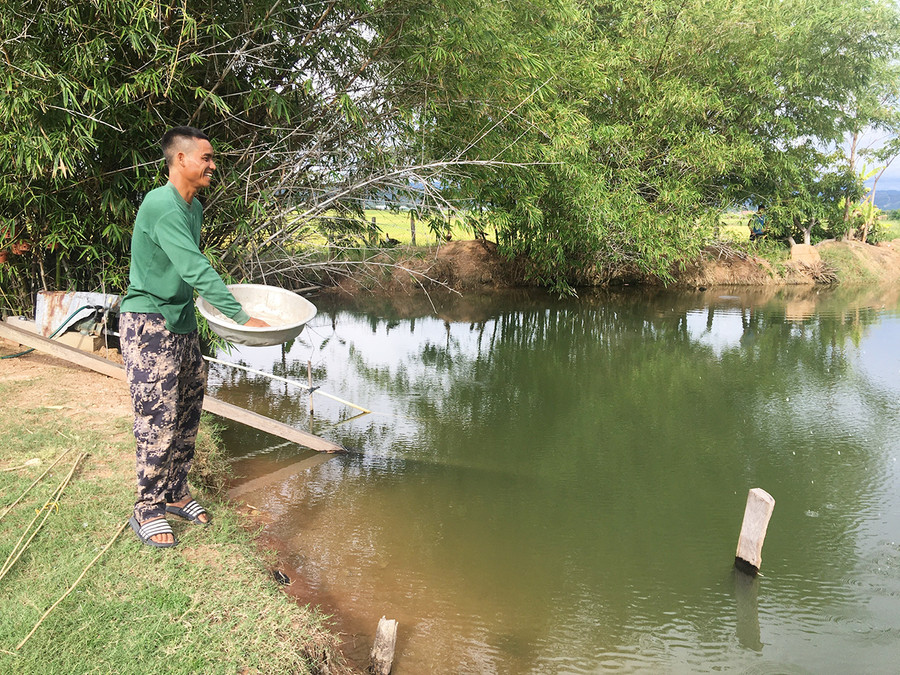 Anh Ksor Troan (làng Voòng Boong) bên ao cá của gia đình mình. Ảnh: RÔ H'OK  Anh Ksor Troan (làng Voòng Boong) bên ao cá của gia đình mình. Ảnh: RÔ H'OK