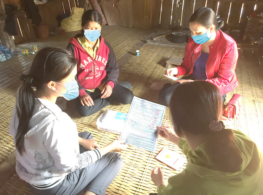 Giáo viên Trường Mẫu giáo Hoa Pơ Lang hướng dẫn chị Đinh Thị Phẻn (làng Brang-Đak-Kliết, xã Ya Hội) làm thủ tục nhập học cho con. Ảnh: Nguyễn Hiền