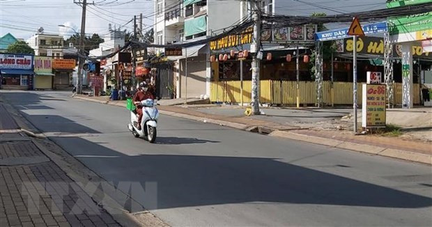 Người đi giao hàng cho các hộ dân theo khung giờ khu vực đường Đình Phong Phú, thành phố Thủ Đức, Thành phố Hồ Chí Minh. (Ảnh: Hồng Nhung/TTXVN)