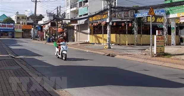 Người đi giao hàng cho các hộ dân theo khung giờ khu vực đường Đình Phong Phú, thành phố Thủ Đức, Thành phố Hồ Chí Minh. (Ảnh: Hồng Nhung/TTXVN)