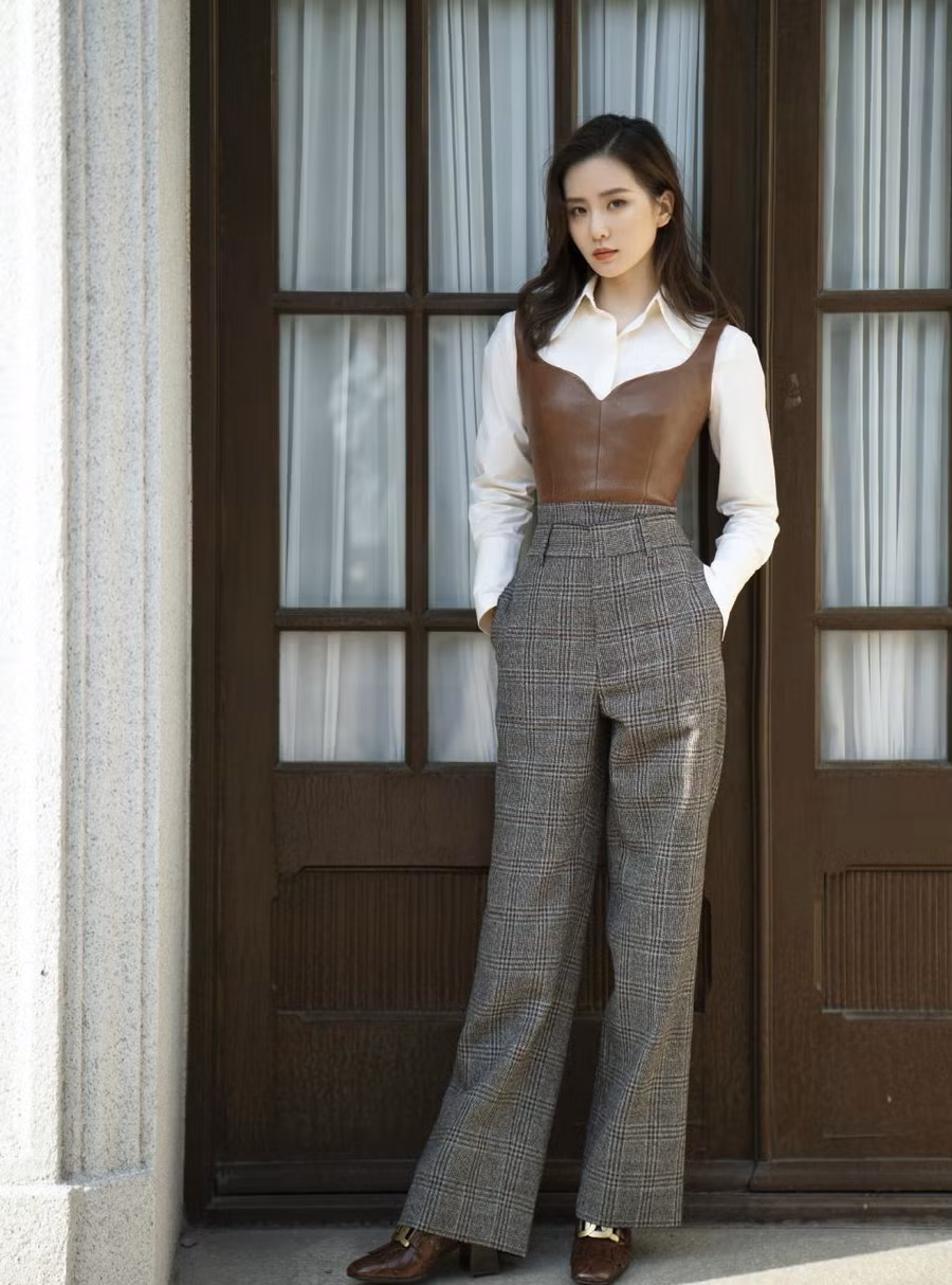 Diện layer mang phong cách retro gồm quần kẻ mix cùng áo sơ mi và corset da, Lưu Thi Thi càng thể hiện đẳng cấp thời trang sành điệu của mình trong làng giải trí Cbiz. Set đồ vừa giúp bà xã Ngô Kỳ Long tôn vòng eo thon gọn mà còn khoe khéo đôi chân dài thẳng tắp.