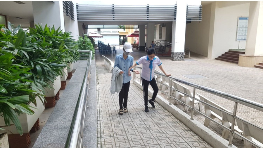 Tuyết Nhung (phải) được bạn dìu đến lớp trong một buổi đi học. Ảnh: NVCC