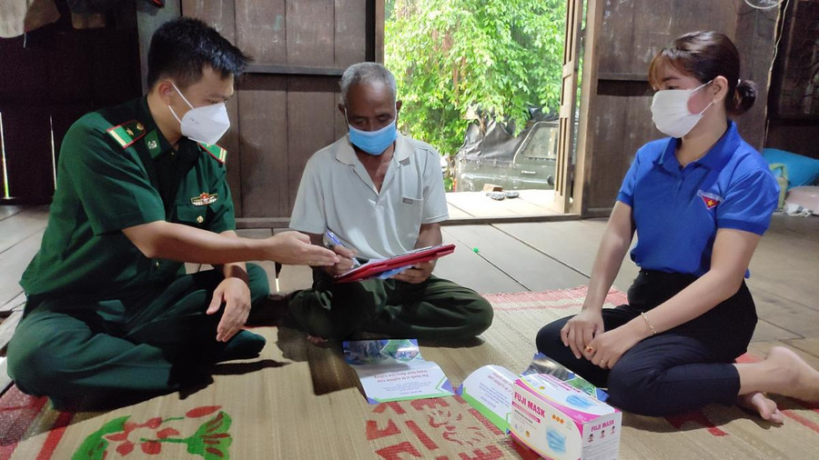 Thiếu tá Nguyễn Hữu Lương (bìa trái) xuống địa bàn xã Krông Na tuyên truyền phòng, chống dịch COVID-19 cho người dân.