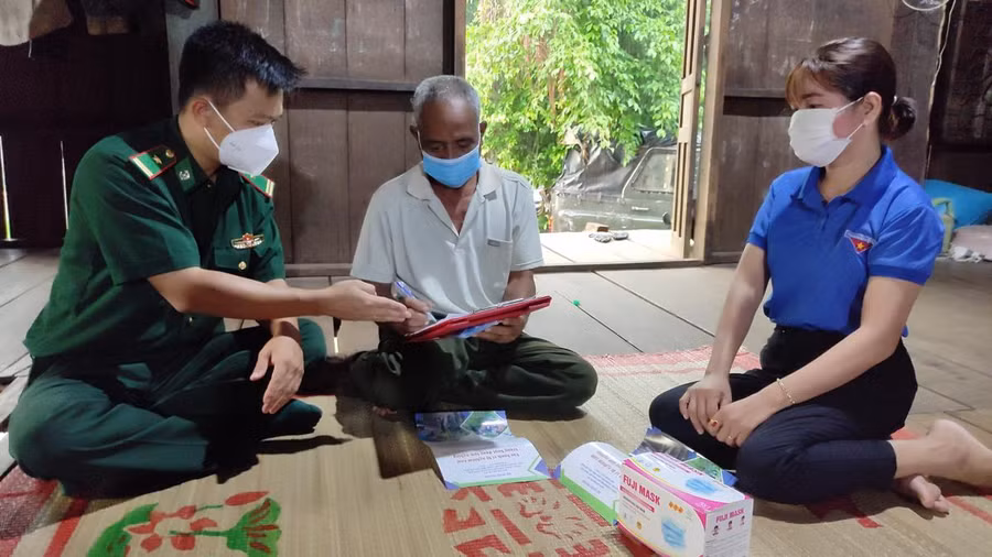 Thiếu tá Nguyễn Hữu Lương (bìa trái) xuống địa bàn xã Krông Na tuyên truyền phòng, chống dịch COVID-19 cho người dân.