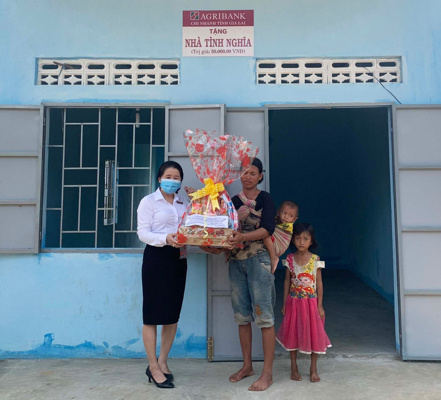 Cán bộ Ngân hàng Nông nghiệp và PTNT huyện Phú Thiện tặng quà trong lễ bàn giao nhà tình nghĩa cho hộ dân xã Ia Yeng. Ảnh: Thiên Di