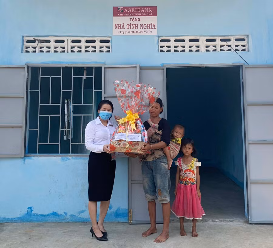 Cán bộ Ngân hàng Nông nghiệp và PTNT huyện Phú Thiện tặng quà trong lễ bàn giao nhà tình nghĩa cho hộ dân xã Ia Yeng. Ảnh: Thiên Di
