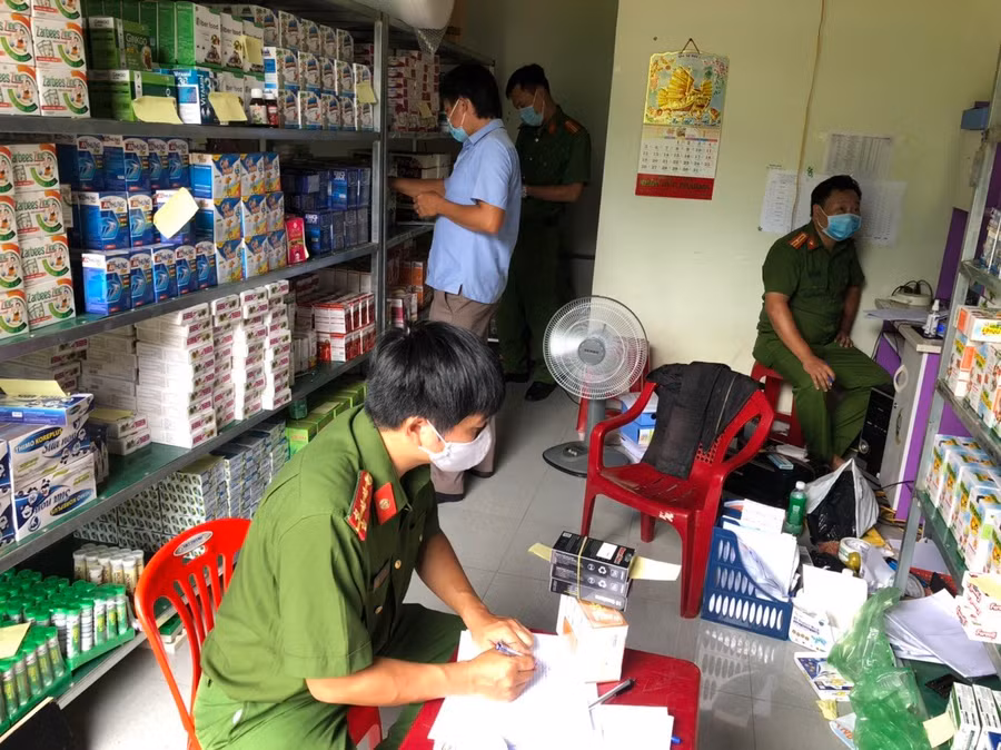 Lực lượng chức năng lập biên bản thu giữ các mặt hàng tại kho của Công ty TNHH Nhân Đức Pharma. Ảnh: Công an cung cấp