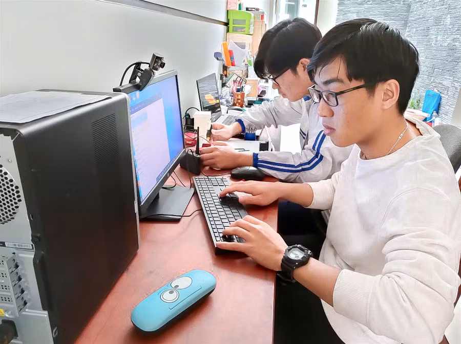 Hai em Nguyễn Quang Thuật (phía trước; lớp 12A1, Trường THPT Pleiku) và Tống Duy Quang cùng nghiên cứu mô hình “Cổng trường thông minh” (ảnh chụp tháng 12-2020). Ảnh: Mộc Trà