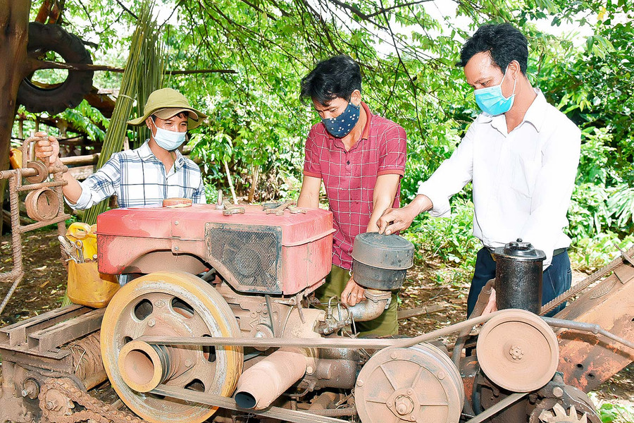 Anh Hro (đứng giữa, làng Ar Dôch Ktu) đưa máy móc vào sản xuất để giảm sức lao động. Anh cho biết: Gia đình có 3 ha trồng chuối, 1 ha cà phê, 800 trụ hồ tiêu, 4 ha mì, 2 ha lúa rẫy...; mỗi năm cho thu nhập gần 200 triệu đồng. 