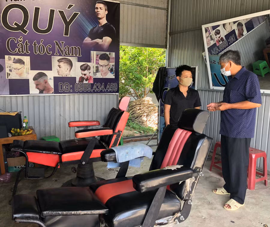 Anh Quách Hoàng Công Quý-TDP 8, thị trấn Phú Túc (bìa trái) bị ảnh ảnh hưởng bởi dịch covid 19 phải đóng cửa tiệm cắt tóc. Ảnh: Lê Nam