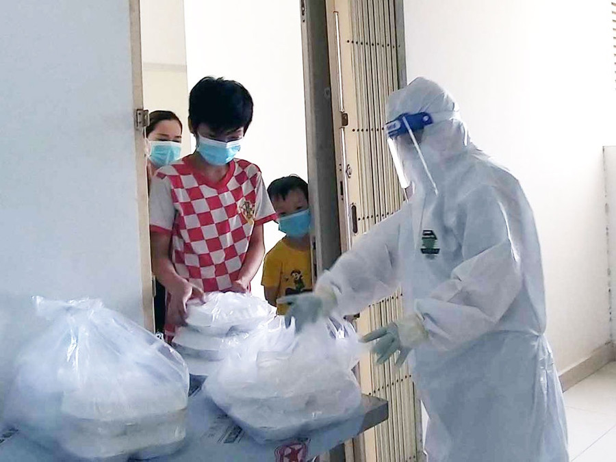 Thành viên đội hậu sự tham gia phân phối cơm cho bệnh nhân