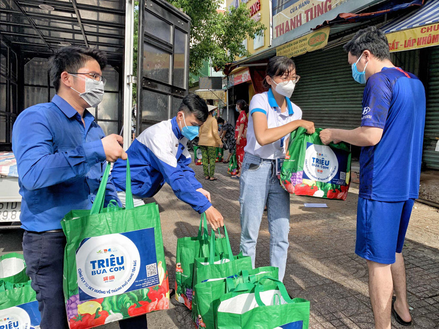 Các thành viên nhóm từ thiện Fly To Sky-Chi nhánh TP. Hồ Chí Minh tặng quà cho người dân quận Bình Tân. Ảnh: Thi Minh