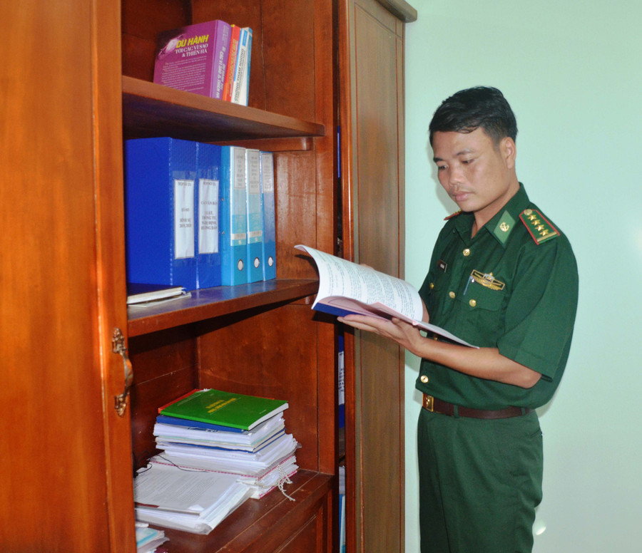 Đại úy Phan Văn Hùng nghiên cứu tài liệu phục vụ nhiệm vụ chuyên môn. Ảnh: Thiên Thanh
