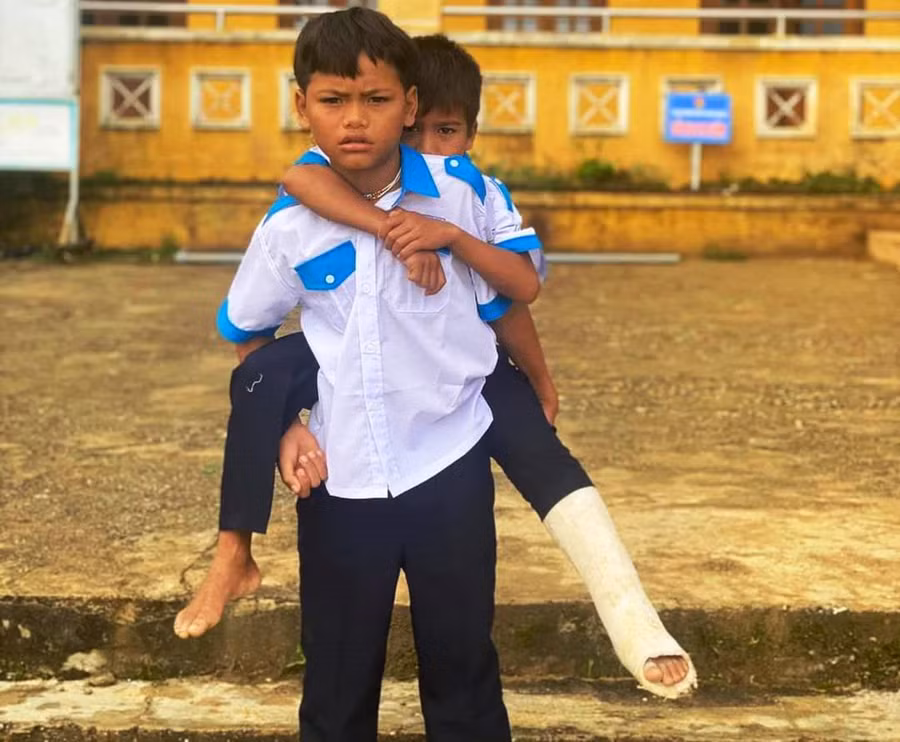 Hồ Hoàng Khánh Luân được bạn cõng đến trường. Ảnh: M. Hạnh