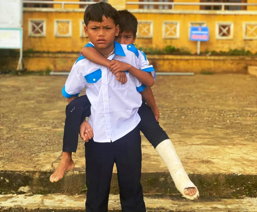 Hồ Hoàng Khánh Luân được bạn cõng đến trường. Ảnh: M. Hạnh