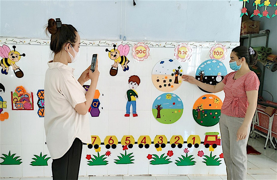 Cô Nguyễn Thị Hạ (áo đỏ)-giáo viên Trường Mẫu giáo Hoa Mai (huyện Chư Pưh) cùng đồng nghiệp thực hiện video giới thiệu về lớp học để gửi cho trẻ. Ảnh: Mộc Trà