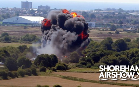 Máy bay rơi xuống đường cao tốc (có cây xanh hai bên), tạo ra một quả cầu lửa lớn.