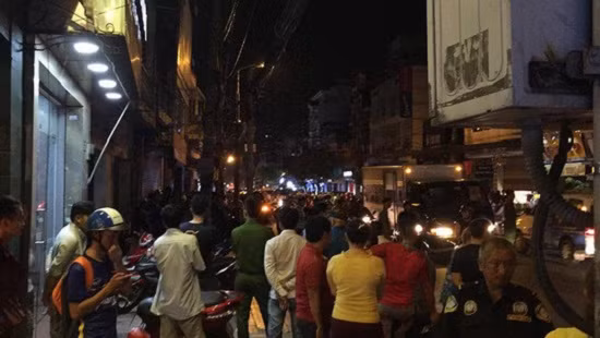 Người dân theo dõi lực lượng chức năng khám nghiệm hiện trường vụ việc.