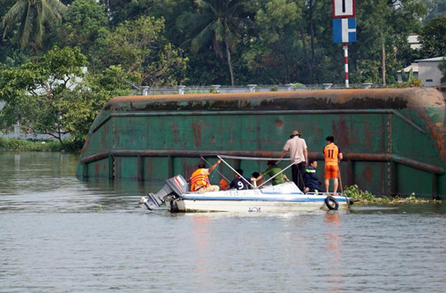 Cảnh sát cứu hộ đang tìm cách lặn vào trong sà lan tìm ba bà cháu.